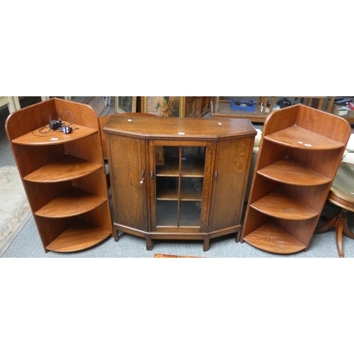 175 - An oak side cabinet with canted front, 97 cm wide x 107 cm tall, central shelves behind glazed door ... 