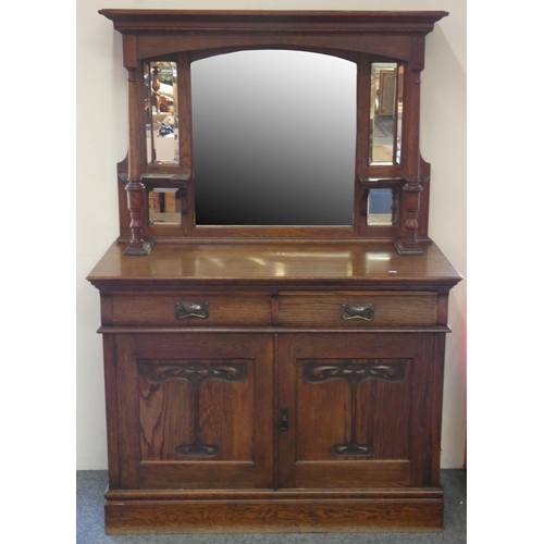 200 - An Arts and Crafts oak mirror backed sideboard, the twin drawer base over cupboards behind stylish c... 