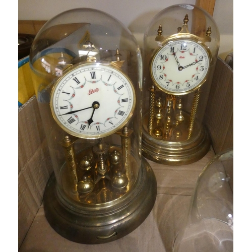 25 - Two glass domed manual wind anniversary clocks, with two spare glass domes.