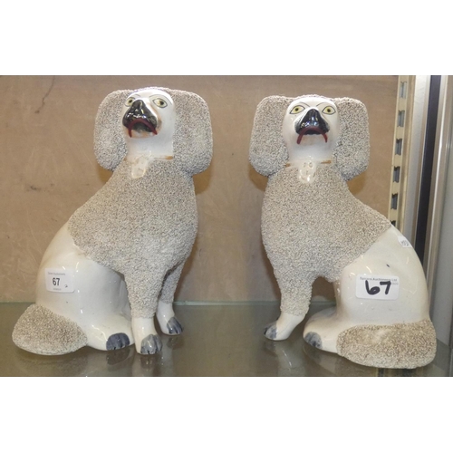 67 - A pair of Stafford-shire pottery spaniels, 24 cm tall.