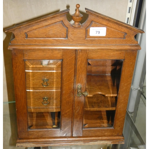 79 - An Oak cabinet with two bevel edged glazed door, the interior with 3 half drawers next to open shelv... 