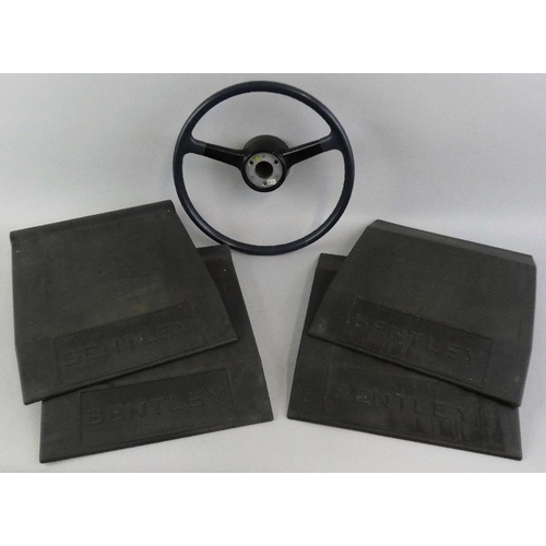 111 - Bentley - a set of four grey rubber garage wheel plates, together with a Bentley steering wheel (5).