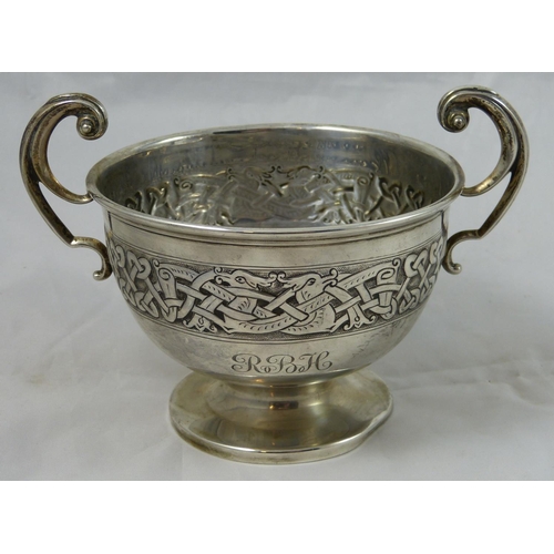 11 - A silver two handled bowl, Birmingham 1920, with a band of embossed Celtic decoration, initialed tog... 