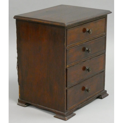 372 - A Victorian mahogany miniature chest of four graduated long drawers, the top one imitating two short... 