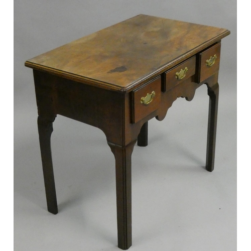 379 - A mahogany side table, with three drawers and shaped apron, 76 x 46 x 69 cm.