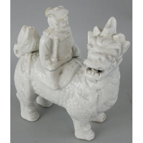 208 - A Chinese blanc de chine figure of a Chinaman sat on a dragon, length 12 cm.