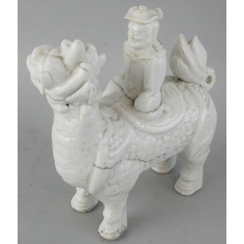 208 - A Chinese blanc de chine figure of a Chinaman sat on a dragon, length 12 cm.