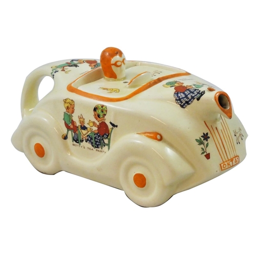 218 - An unusual racing car teapot by James Sadler, with transfer printed nursery scenes designed by Mabel... 