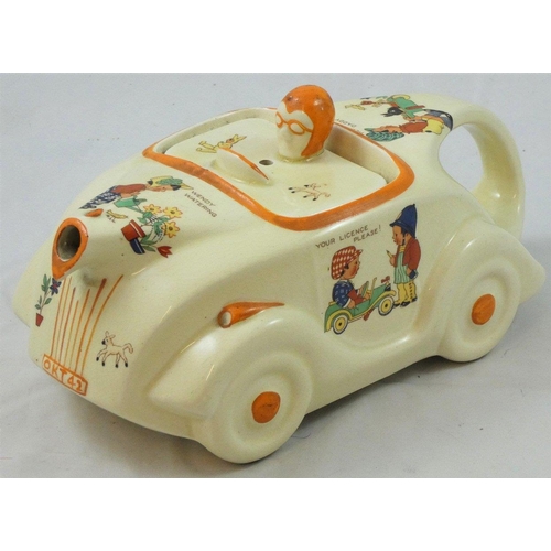 218 - An unusual racing car teapot by James Sadler, with transfer printed nursery scenes designed by Mabel... 