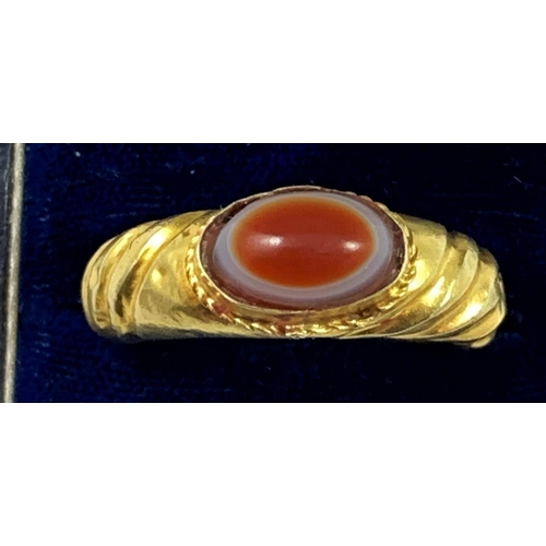 85 - A gold Roman style ring, collet set with a cabochon sardonyx, ribbed tapering shank, size W, weight ... 