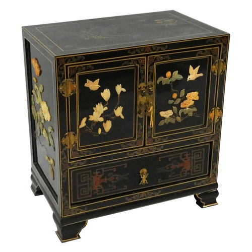 256 - A Chinese black cabinet, the front decorated with applied resin figures in a garden, the sides with ... 