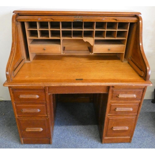 262 - An Edwardian oak kneehole twin pedestal roll top writing desk, the S shaped tambour roll enclosing a... 