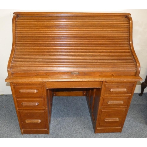 262 - An Edwardian oak kneehole twin pedestal roll top writing desk, the S shaped tambour roll enclosing a... 