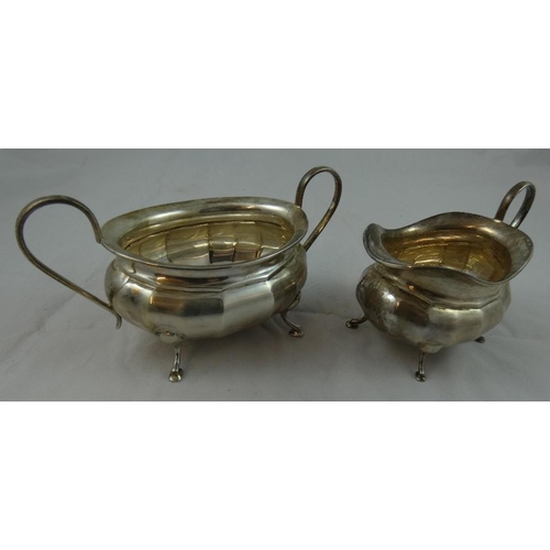 35 - A silver three piece tea service, by Viners, Sheffield 1932, of oval panelled form, raised on four l... 