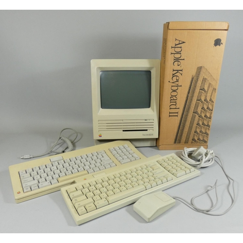 109 - An early Macintosh SE personal computer, together with three keyboards (one boxed), mouse, power cab... 