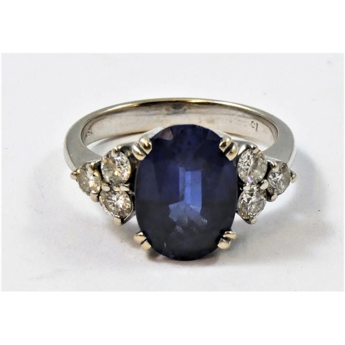 44 - An 18ct white gold synthetic sapphire and diamond ring, claw set with an oval mixed cut stone, weigh... 