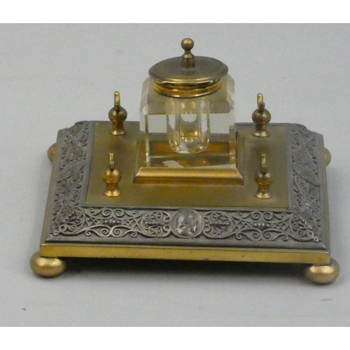 137 - A Victorian brass and metal square ink stand, with scholar masks, clear glass bottle, two pen stands... 