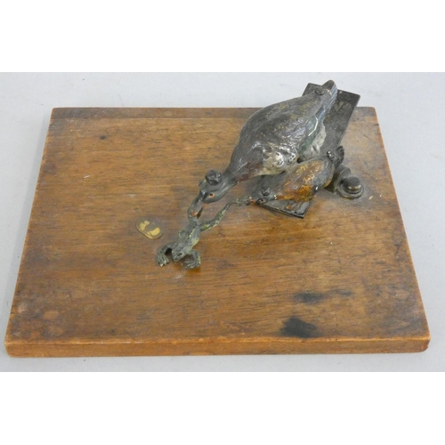 146 - An Austrian oak and cold painted bronze note holder, the sprung loaded clamp in the form of two duck... 