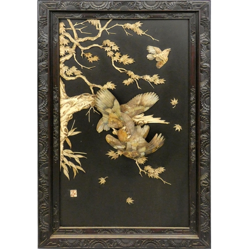 210 - A Chinese hardwood and mother of pearl panel, c.1900, comprising a pair of fighting eagles amongst b... 