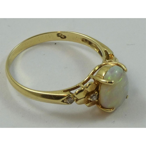 78 - A gold, opal and diamond dress ring, stamped 585, claw set with a cabochon stone flanked by brillian... 