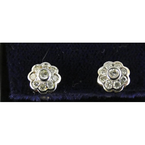 90 - A pair of 9 ct gold and diamond cluster earstuds, rub over set with brilliant cut stones.