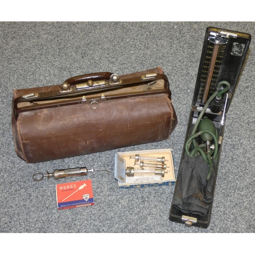 184 - A vintage doctors medicinal satchel, containing boxed blood pressure monitor and various syringes, m... 