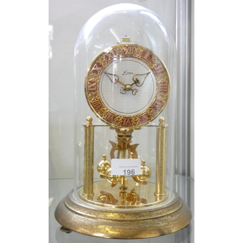 196 - An anniversary clock under glass dome by Kern, roman numerals, height 31cm.