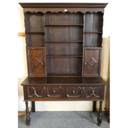 273 - A dark oak dresser early 20th century open top with two side cupboards over two drawer base on raise... 