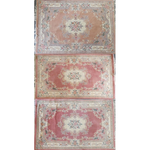 283 - A pair of famile rose Chinese rugs, with tassel ends, 270x185cm and a similar lighter example (3)