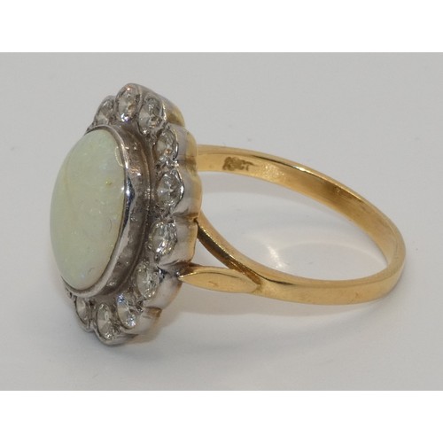 104 - An 18ct gold opal and diamond cluster ring, collet set with an oval stone, 12 x 10 mm, bordered by 1... 