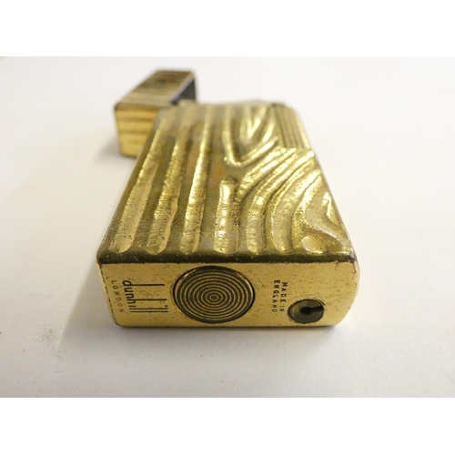 144 - A Dunhill 70 cigarette lighter, case, paperwork, another cased Dunhill lighter and a third, uncased.