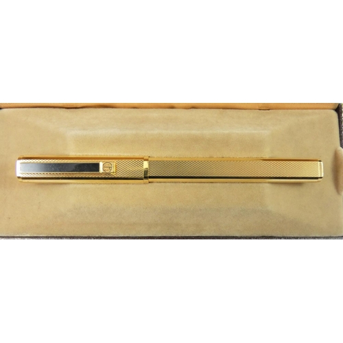 79 - Dunhill, a gilt metal Gemline fountain pen, with engine turned body, 18K gold knib, warranty card, b... 