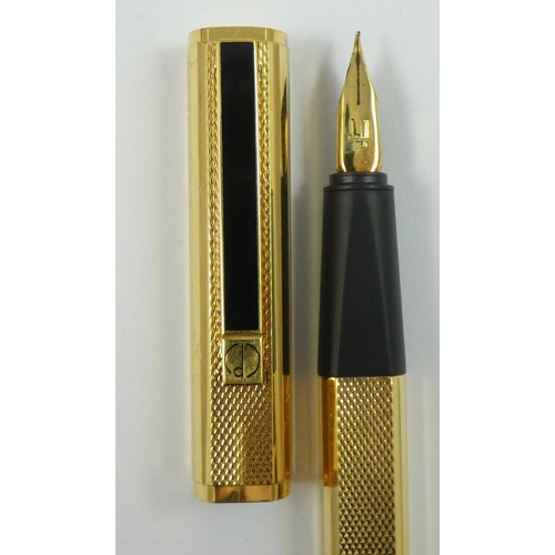 79 - Dunhill, a gilt metal Gemline fountain pen, with engine turned body, 18K gold knib, warranty card, b... 