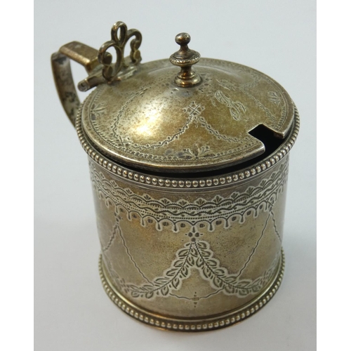 68 - A Victorian silver mustard pot, London 1868, of circular form with bright cut engraved decoration, r... 