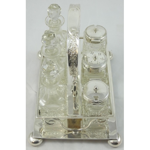 2 - An electroplate six bottle table cruet, the frame with scroll handle, raised on four ball feet, cont... 