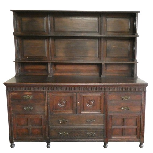 472 - An Edwardian oak two rack dresser, the base with central two door cupboard over two drawers, flanked... 