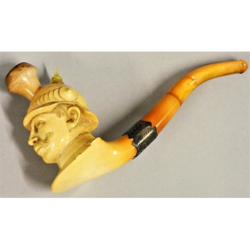 234 - A meerschaum pipe, carved to depict Kaiser Wilhelm II with helmet, silver mount, amber pipe repaired... 