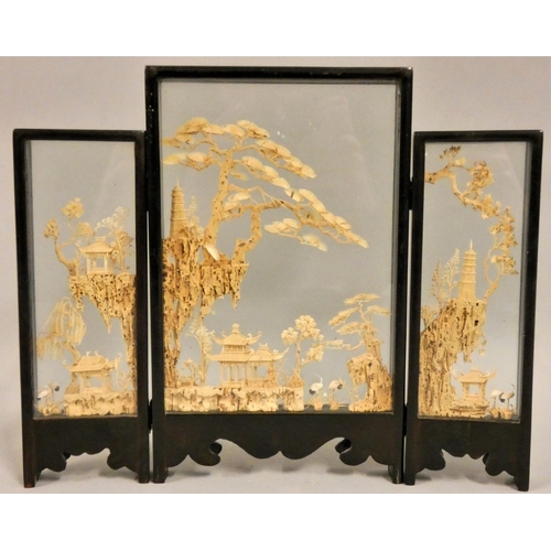 366 - A Chinese carved wood triptych, depicting pagodas, storks and trees, glazed panels, height 25 cm.