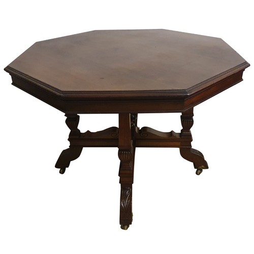 490 - An Edwardian mahogany octagonal dining table, raised on four tapering supports with carved terminals... 