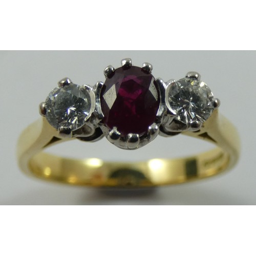 125 - An 18ct gold ruby and diamond three stone ring, claw set with an oval mixed cut stone flanked by bri... 