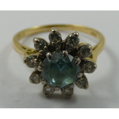 135 - A blue zircon and diamond cluster ring, claw set with a brilliant cut stone, bordered by ten brillia... 