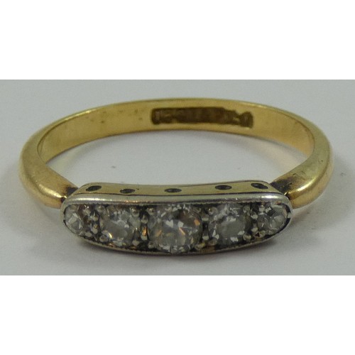 148 - An Edwardian 18 ct gold and diamond five stone ring, channel set with graduated old cut brilliants, ... 