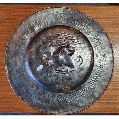 196 - A Newlyn School hammered copper charger, decorated with a galleon in full sail, with hammered border... 