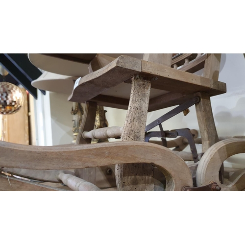 198 - A Victorian beech metamorphic chair, converting from a rocking chair to a high chair, wheels, one le... 