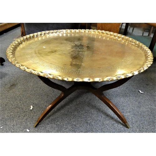 261 - A brass topped table, 90cm diameter 39cm tall, the top with raised border and central floral pattern... 