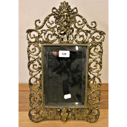 128 - A cast brass easel mirror, with mask and scroll pierced border, 44cm.