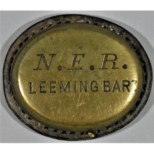 181 - A NER Leeming Bar brass and leather cash bag label.