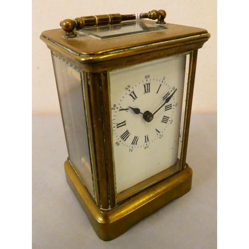 81 - A brass cased manual wind carriage clock with white enamelled dial and Roman numerals.