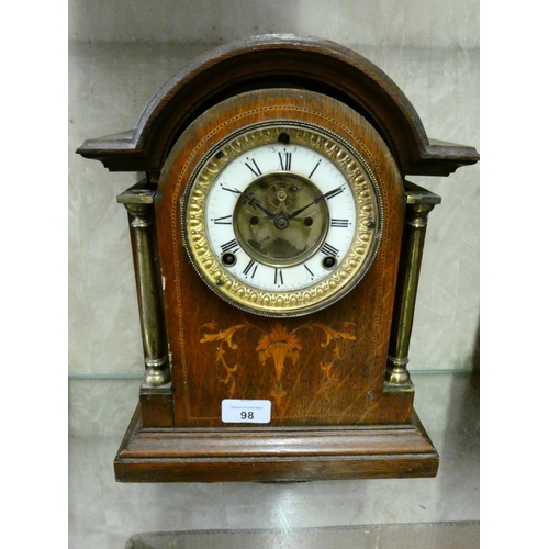 98 - An inlaid oak cased mantle clock with arched top and brass columns.
32cm tall. (AF)