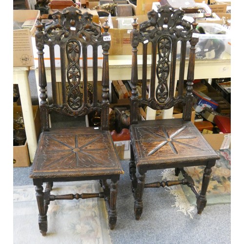 432 - A Victorian pair of stained oak hall chairs with carved decoration.